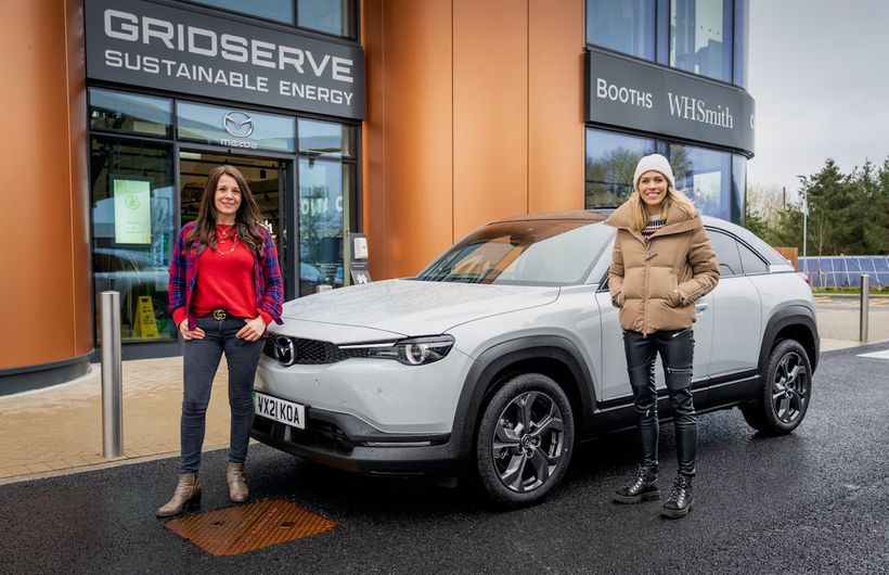 Ginny Buckley and Nicki Shields at Gridserve electric car charging station with an Mazda MX-30